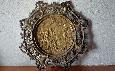 Antico piatto in bronzo con figure in rilievo