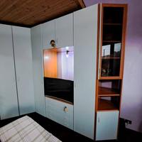 Armadio ad angolo celeste/azzurro e color legno.