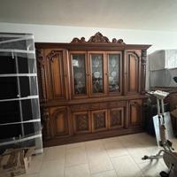 Set soggiorno con vetrina, tavolo, sedie e madia.