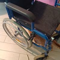 carrozzina pieghevole per disabili di colore blu.