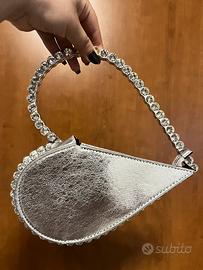 Borsa a forma di cuore color argento.