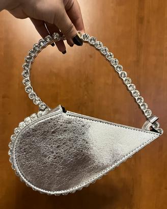 Borsa a forma di cuore color argento.