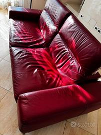 Divano in pelle rosso e poltrona in tessuto