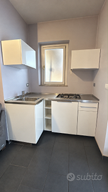 Cucina ad angolo con tavolo ed elettrodomestici