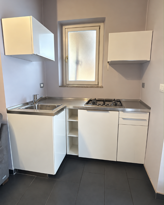 Cucina ad angolo con tavolo ed elettrodomestici