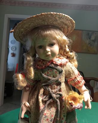 bambola in ceramica con cappello di paglia 