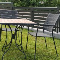 Tavolo da giardino con due sedie in metallo.