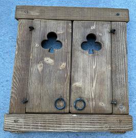 Finestrella con scuri traforati. Fiori