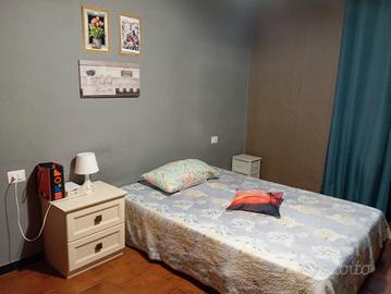 Una stanza con bagnio e cucina in comune