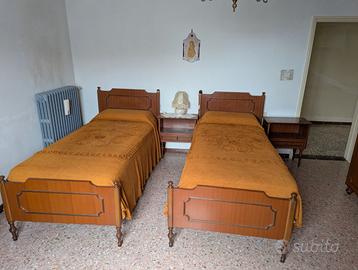 Coppia di letti singoli con comodini e specchio