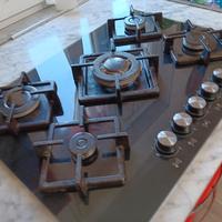 piano cottura con base in vetro scuro