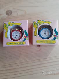 Due piccoli orologi a forma di sveglia