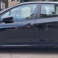 Peugeot 208 colore nero con cerchi in lega.