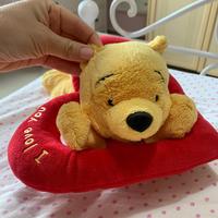 Peluche a forma di Winnie the Pooh sopra un cuore