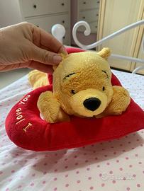 Peluche a forma di Winnie the Pooh sopra un cuore