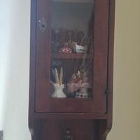 Vetrina a pensile in legno scuro.