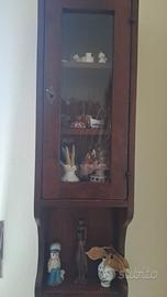 Vetrina a pensile in legno scuro.