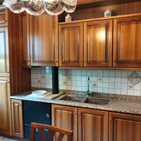 Cucina in noce completa di elettrodomestici.