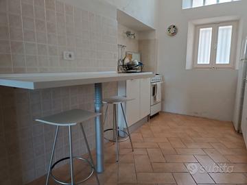 piccola cucina con angolo cottura tavolo sgabelli