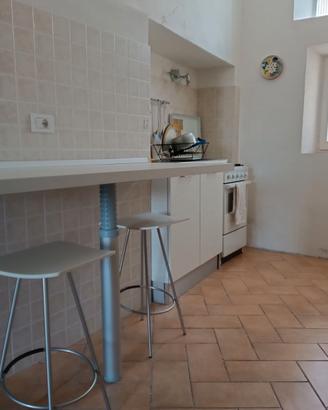 piccola cucina con angolo cottura tavolo sgabelli