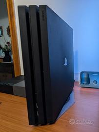 Ps4 Pro con base verticale, cuffia e videogiochi.