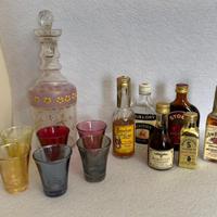 Bottiglia, bicchierini e bottigliette di liquore