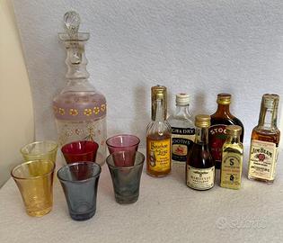 Bottiglia, bicchierini e bottigliette di liquore