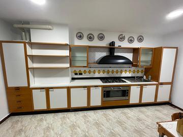 Cucina Binova con elettrodomestici, tavolo e sedie