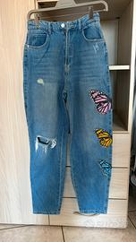 Jeans blu strappati con disegno al lato