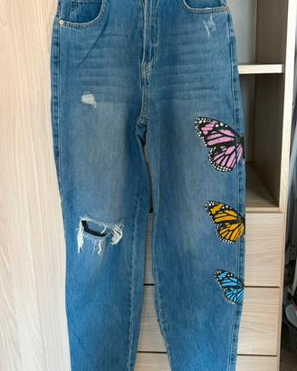 Jeans blu strappati con disegno al lato