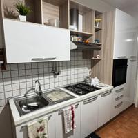 Cucina con elettrodomestici e tavolo