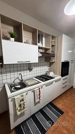 Cucina con elettrodomestici e tavolo