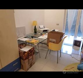 Tavolo in vetro su cavalletti, con sedia.