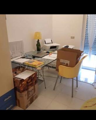 Tavolo in vetro su cavalletti, con sedia.