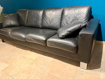 Divano in pelle nera, con due cuscini.