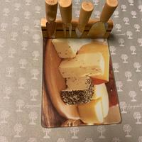 Tagliere in vetro con coltelli per formaggio.