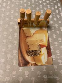 Tagliere in vetro con coltelli per formaggio.