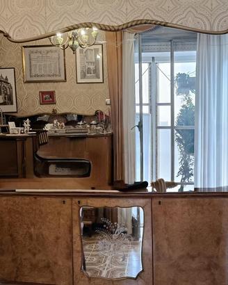 Mobili e tavolo con sedie stile Chippendale.