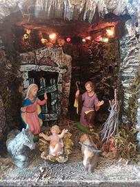 Capanna presepe natalizio illuminata con statuine