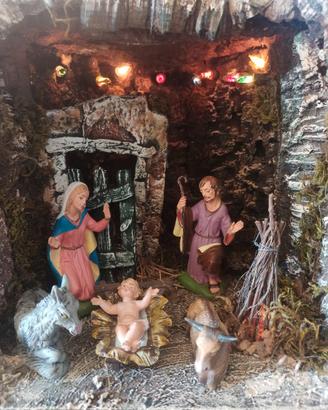 Capanna presepe natalizio illuminata con statuine
