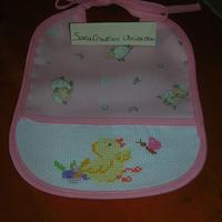 Bavaglino ricamato punto croce pulcino rosa