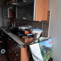 Cucina con elettrodomestici e tavolo con sedie