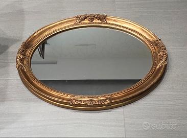specchio ovale con cornice dorata