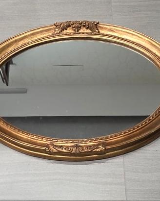 specchio ovale con cornice dorata