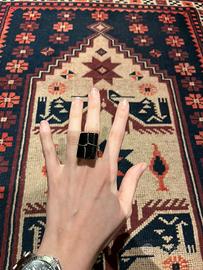 Anello con pietra nera e intreccio in metallo