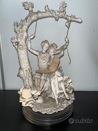 Statua giuseppe armani di coppia in altalena