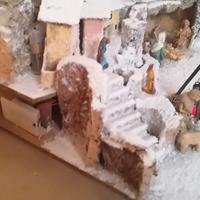 presepe natalizio innevato con paesaggio illuminat