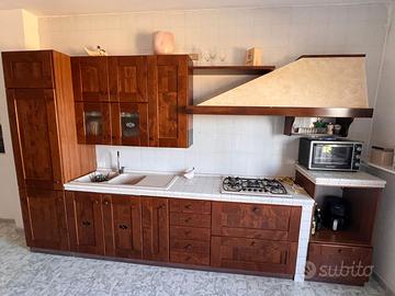 Cucina con ante in noce e piano in mattonelle