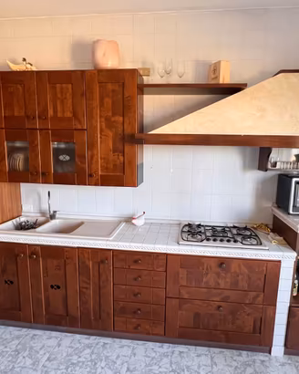 Cucina con ante in noce e piano in mattonelle
