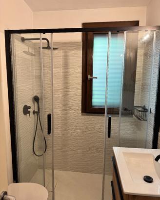 parete doccia nera con accessori e soffione nero